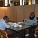 twee studenten aan een tafel met laptop aan het studeren in de kerk